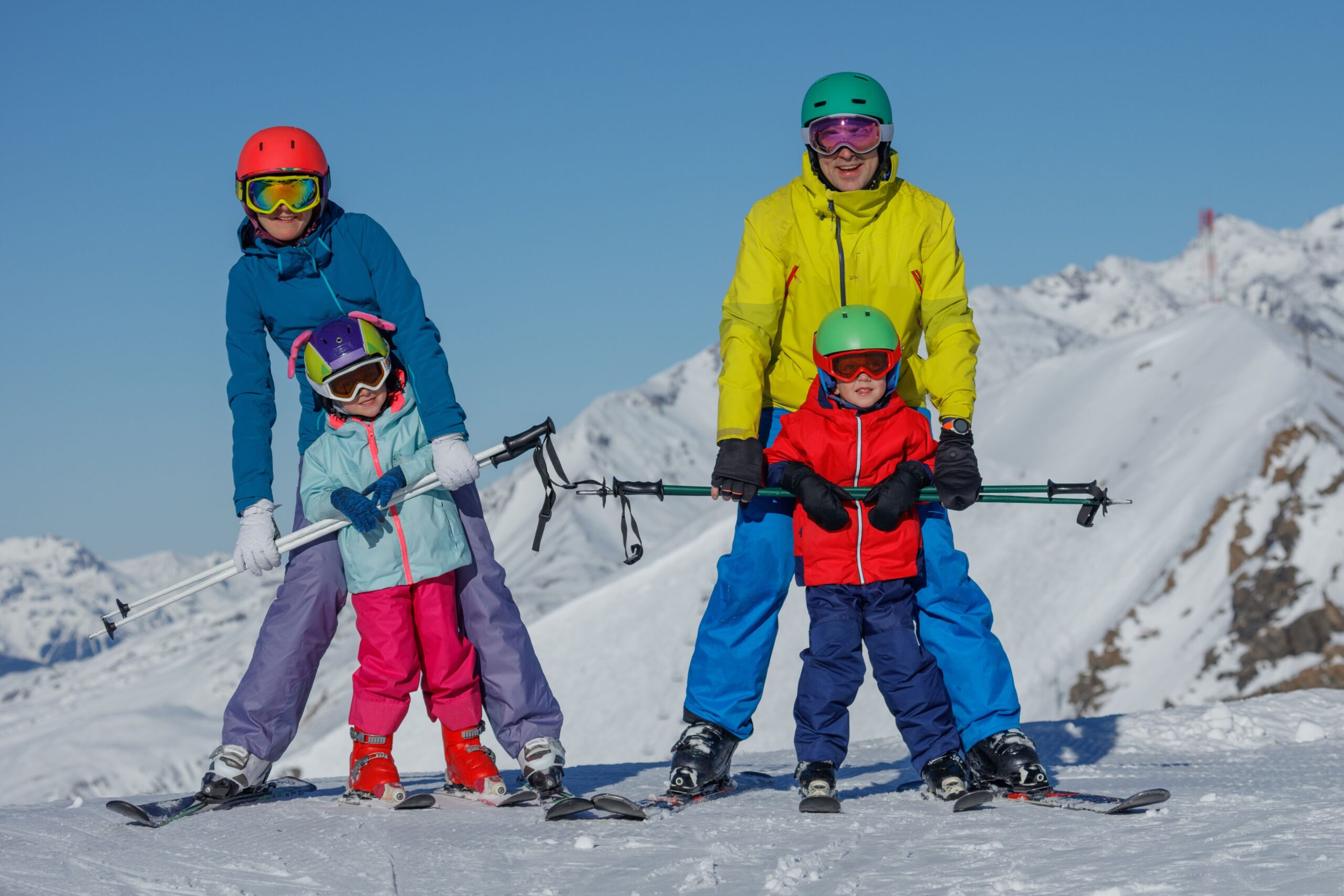 Skiers family enjoying early snow season conditions at European Alps resort destination
