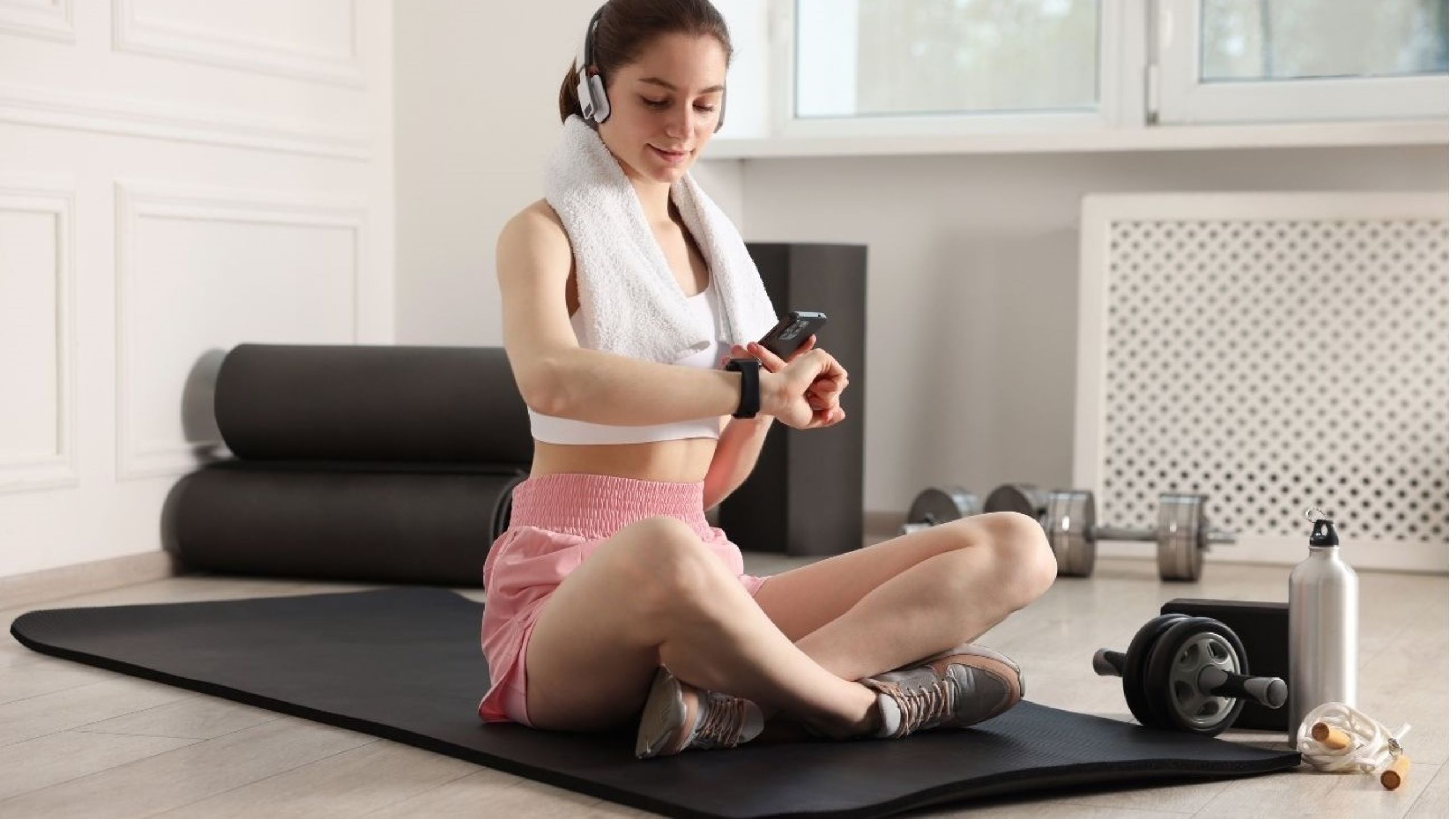 European woman checking wearable fitness tracker showing health data representing wellness trends 2026 with AI-powered personalized technology monitoring heart rate and mental fitness metrics