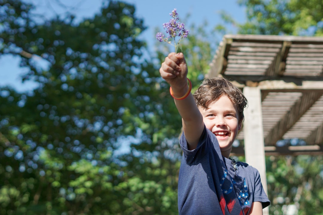 A young boy conducting a hands-on experiment at outdoor science festivals in Europe, surrounded by sunlight