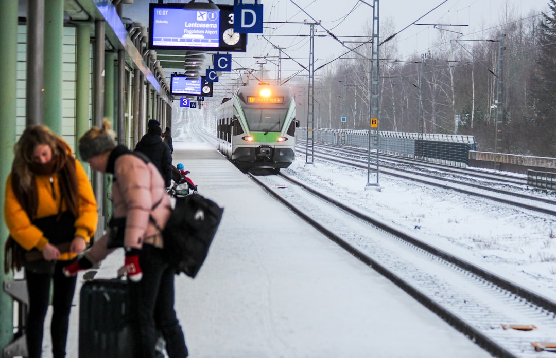 A woman boarding a European train, choosing rail travel to reduce her carbon footprint on a summer holiday