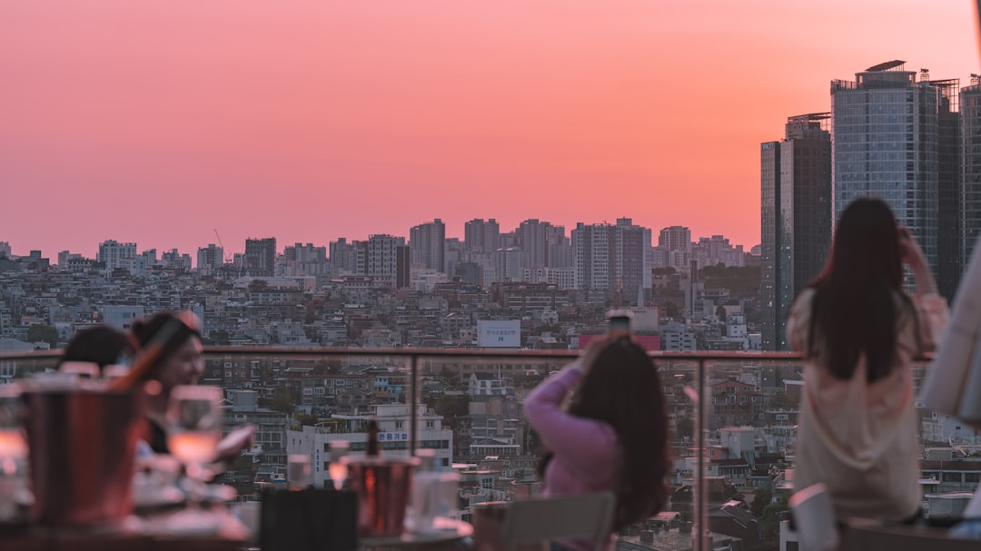 A woman enjoying dinner at one of the most elegant rooftop restaurants in Paris, with the city skyline glowing at sunset