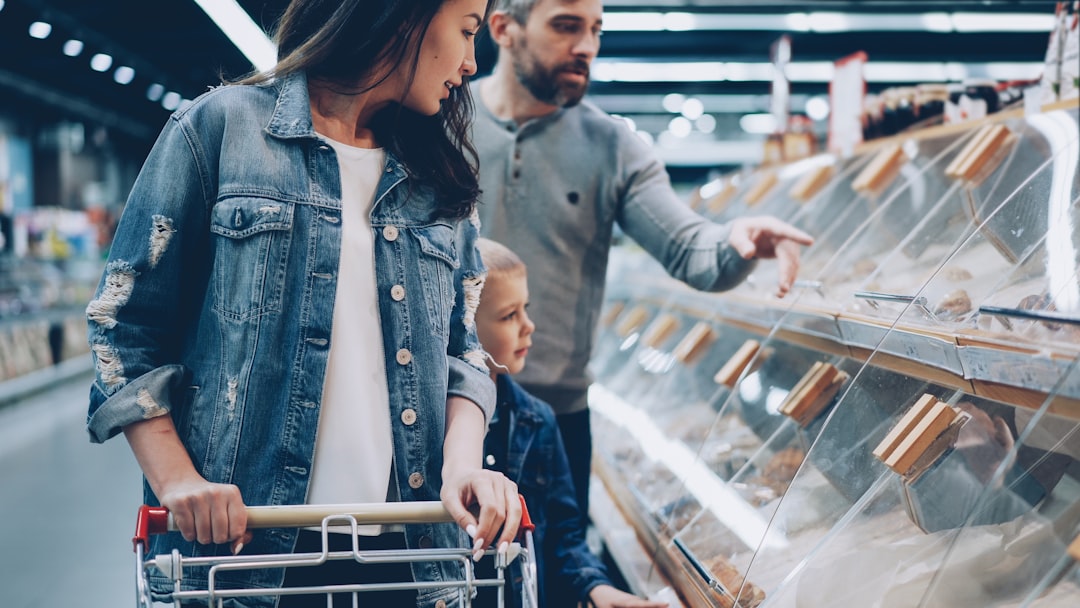 A woman carefully reading the label on certified gluten-free pasta in a European supermarket aisle