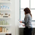 A woman carefully examines a product label in a pharmacy, reflecting the transparency promised by EU cosmetic standards.
