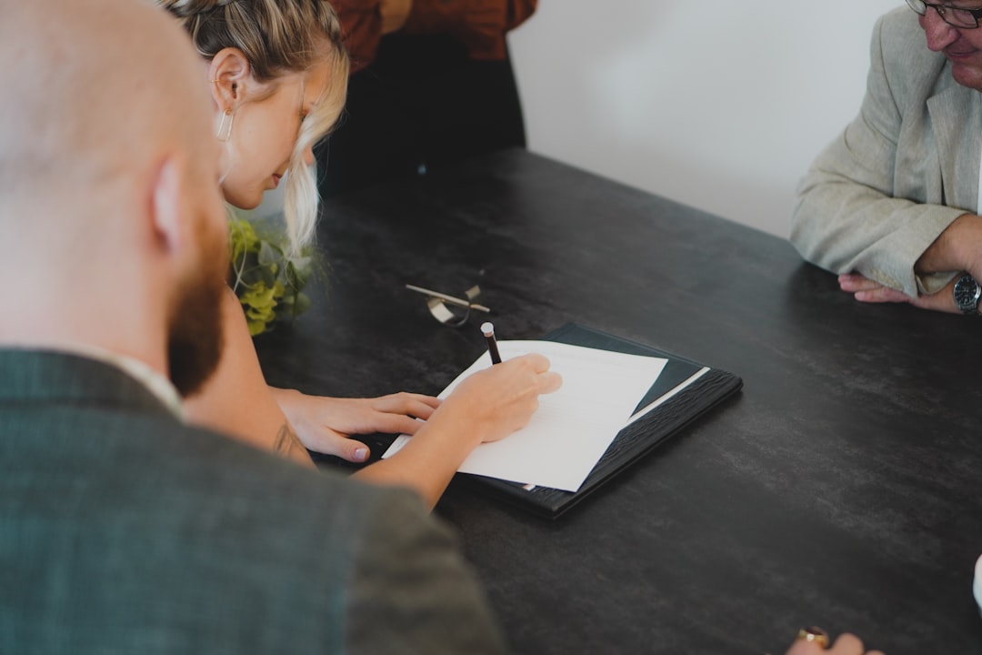 Two professionals reviewing a cross-border EU supplier contract at a modern office desk, discussing key clauses.