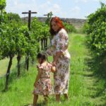 A mother and child share a harvest experience among vineyard rows during the EU grape harvest season