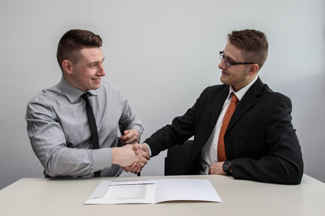 Two startup founders reviewing an EU partnership agreement document at a shared office desk