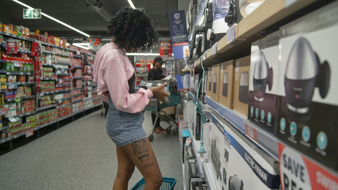 A woman examining the EU energy label on a washing machine in a home appliance store, guided by EU ecodesign rules.